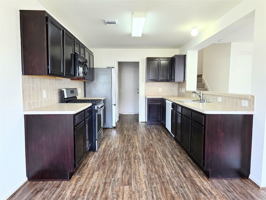 22911 Twisting Maple Court Spring, TX 77373 - Photo 20 of 37 a kitchen with stainless steel appliances granite countertop wooden cabinets a stove top oven a sink and dishwasher