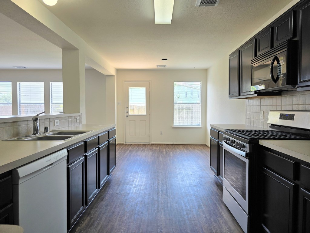 22911 Twisting Maple Court Spring, TX 77373 - Photo 23 of 37 a kitchen with stainless steel appliances a sink cabinets and wooden floor