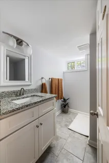 a bathroom with a granite countertop sink and a mirror