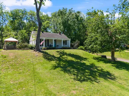 a view of house with backyard and sitting area