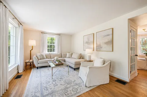 a living room with furniture wooden floor and a large window
