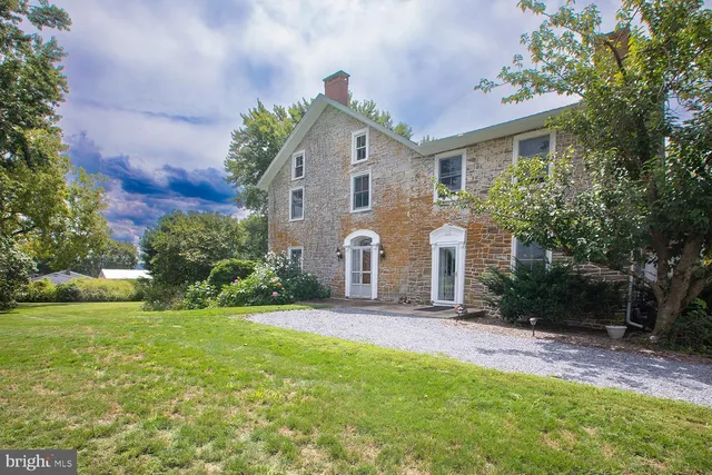 a front view of a house with a yard and trees