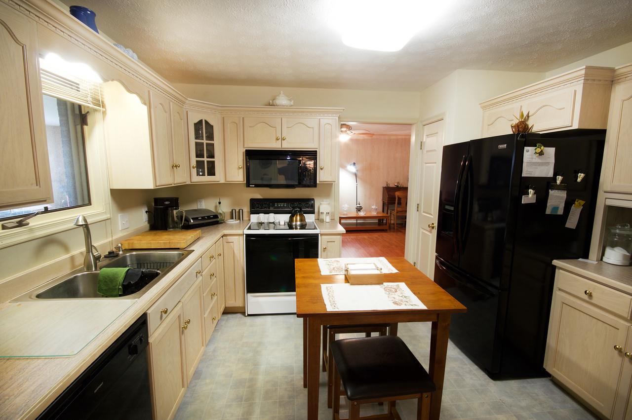 400 Cedar Green Road Staunton, VA 24401 - Photo 36 of 49 a kitchen with a refrigerator a stove a sink dishwasher and wooden cabinets with a dining table