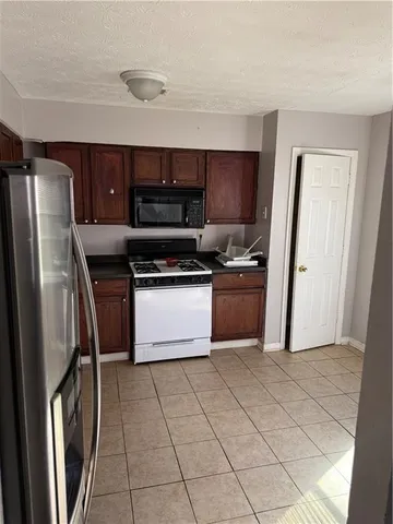a kitchen with stainless steel appliances granite countertop a stove a refrigerator a sink and dishwasher