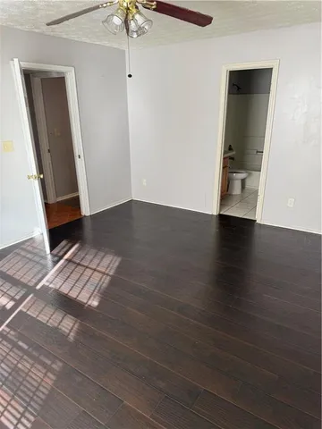 an empty room with wooden floor and staircase