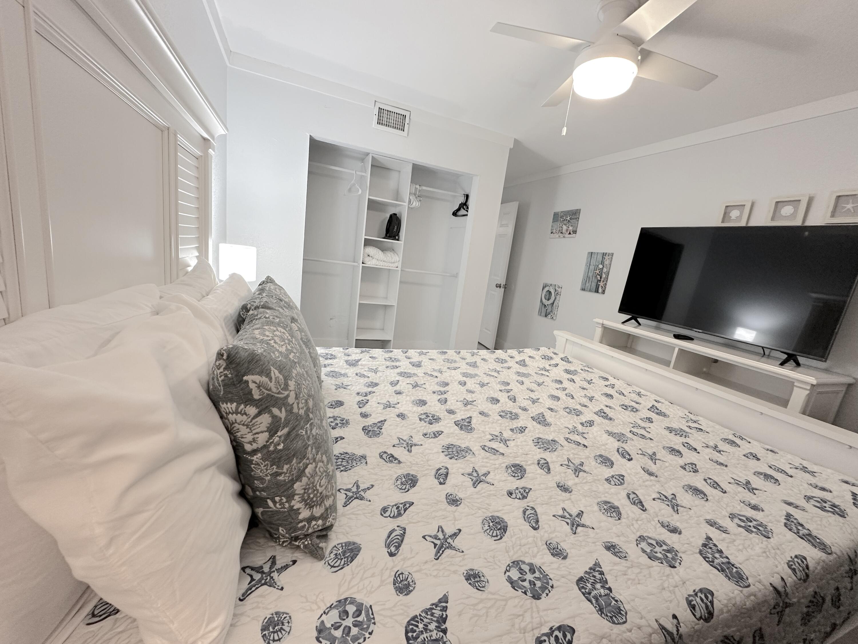 4000 Gulf Terrace Drive, Unit 1000 Destin, FL 32541 - Photo 11 of 37 a bedroom with a bed and a flat screen tv