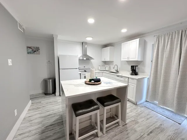 a kitchen with kitchen island a stove a table and chairs in it