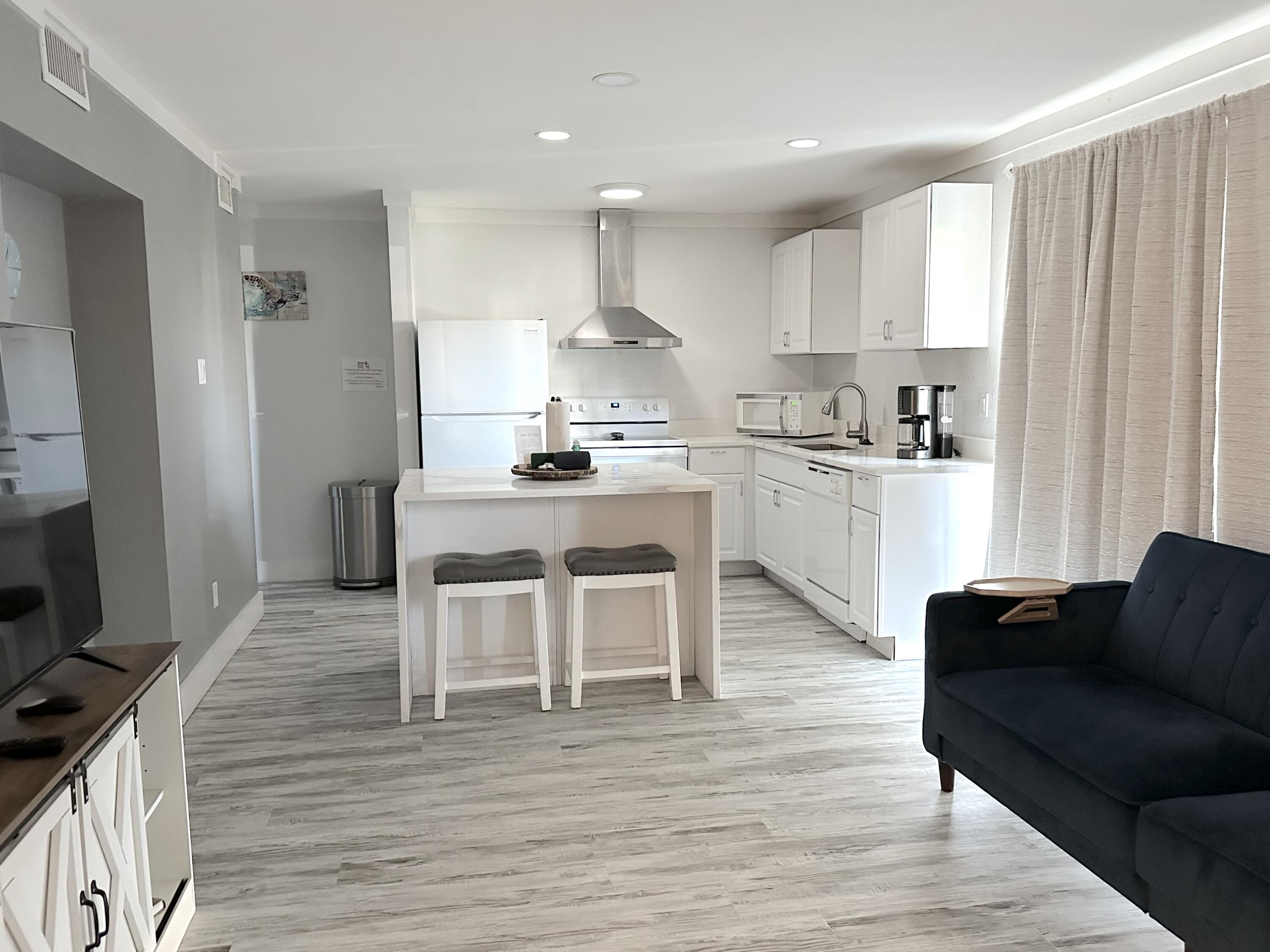 4000 Gulf Terrace Drive, Unit 1000 Destin, FL 32541 - Photo 6 of 37 a kitchen with stainless steel appliances granite countertop a table chairs stove a sink dishwasher and cabinets with wooden floor