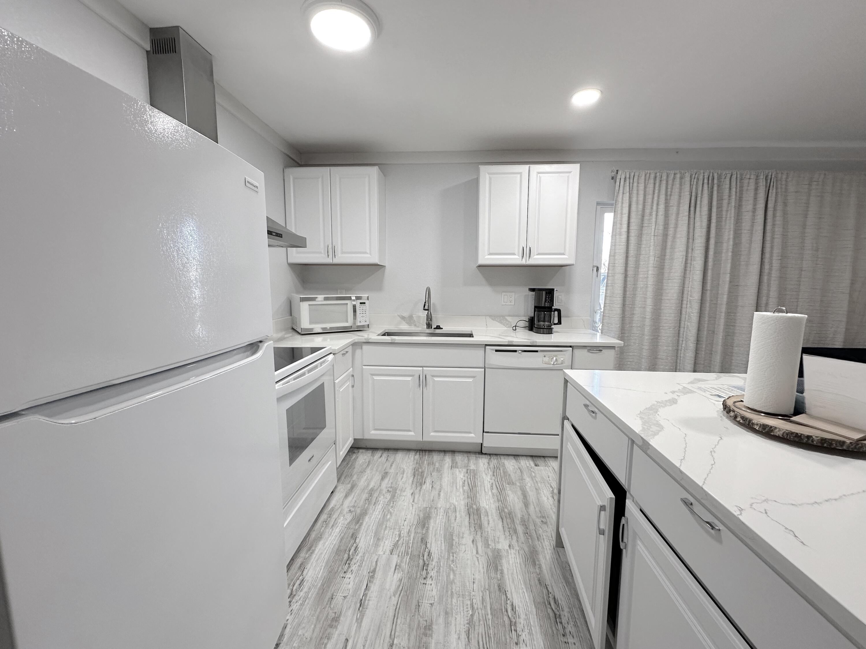 4000 Gulf Terrace Drive, Unit 1000 Destin, FL 32541 - Photo 7 of 37 a kitchen with a sink a stove a refrigerator and white cabinets