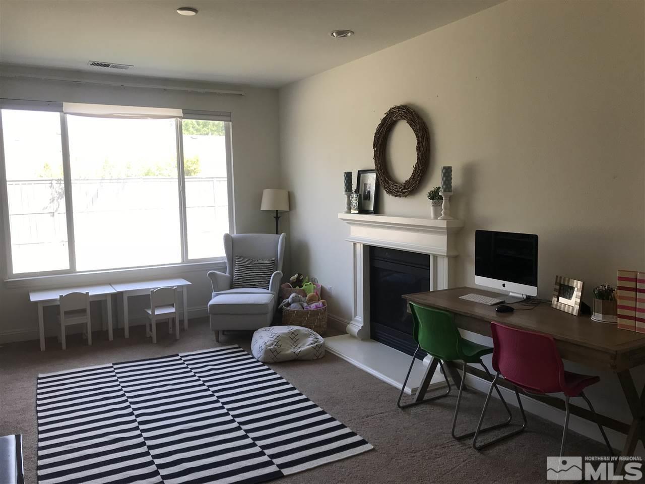 615 Equine Court Reno, NV 89521 - Photo 9 of 25 a living room with furniture a fireplace a rug and a window