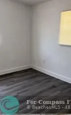 a view of a room with wooden floor and a window