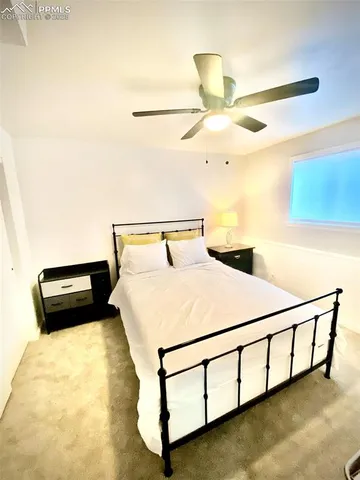 a bedroom with a bed and a ceiling fan