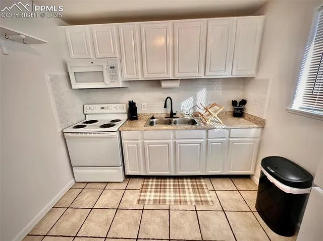 a kitchen with a sink a stove a microwave and cabinets