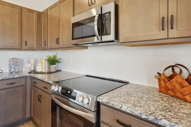 a kitchen with granite countertop a stove a sink and dishwasher