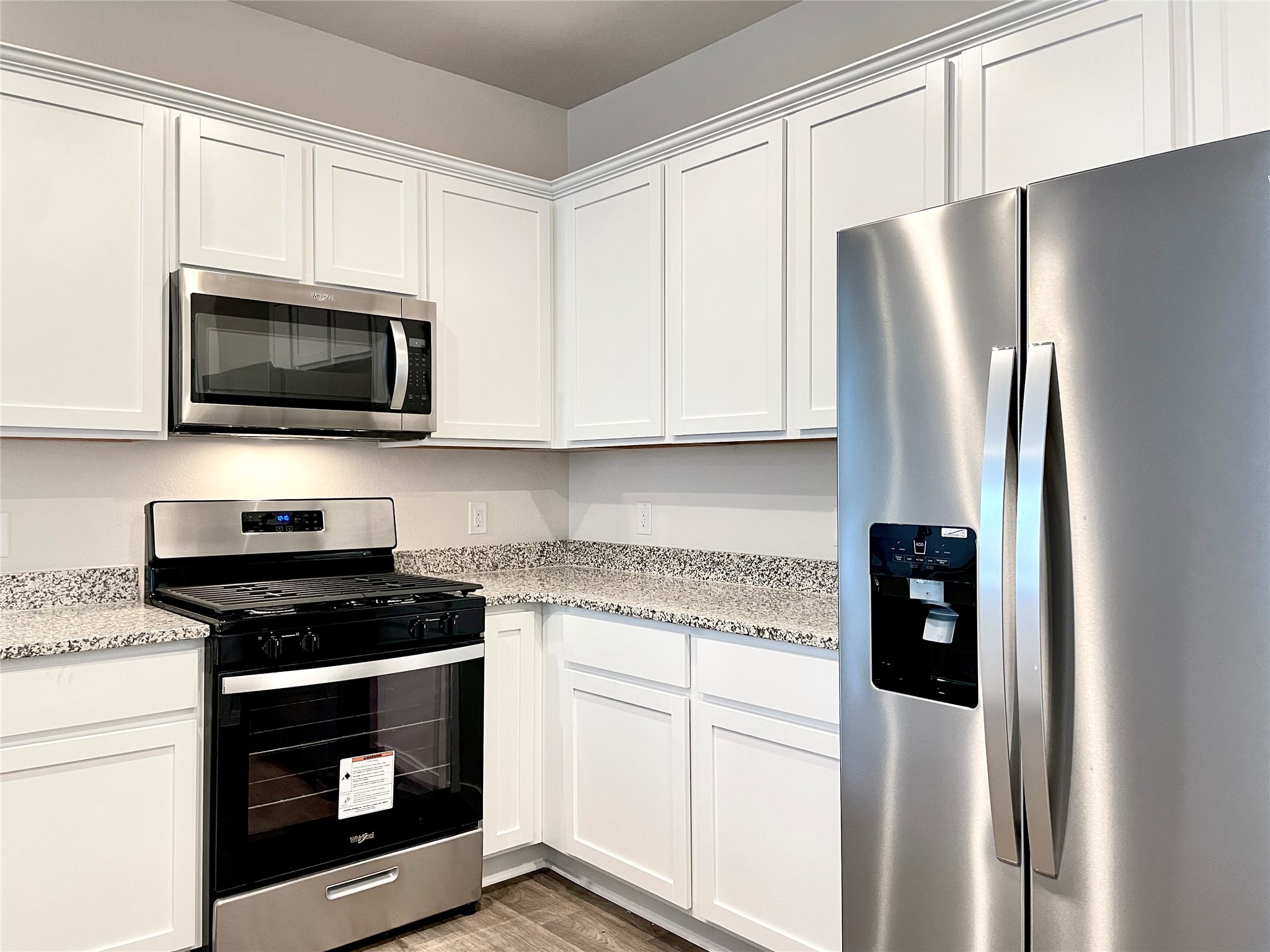 467 Evergreen Sumac Loop Kyle, TX 78640 - Photo 11 of 40 a kitchen with granite countertop white cabinets and stainless steel appliances