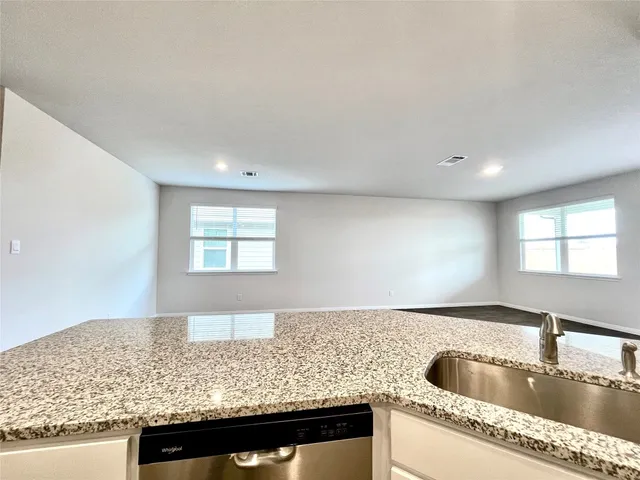 a kitchen with granite countertop a sink and a wooden floor