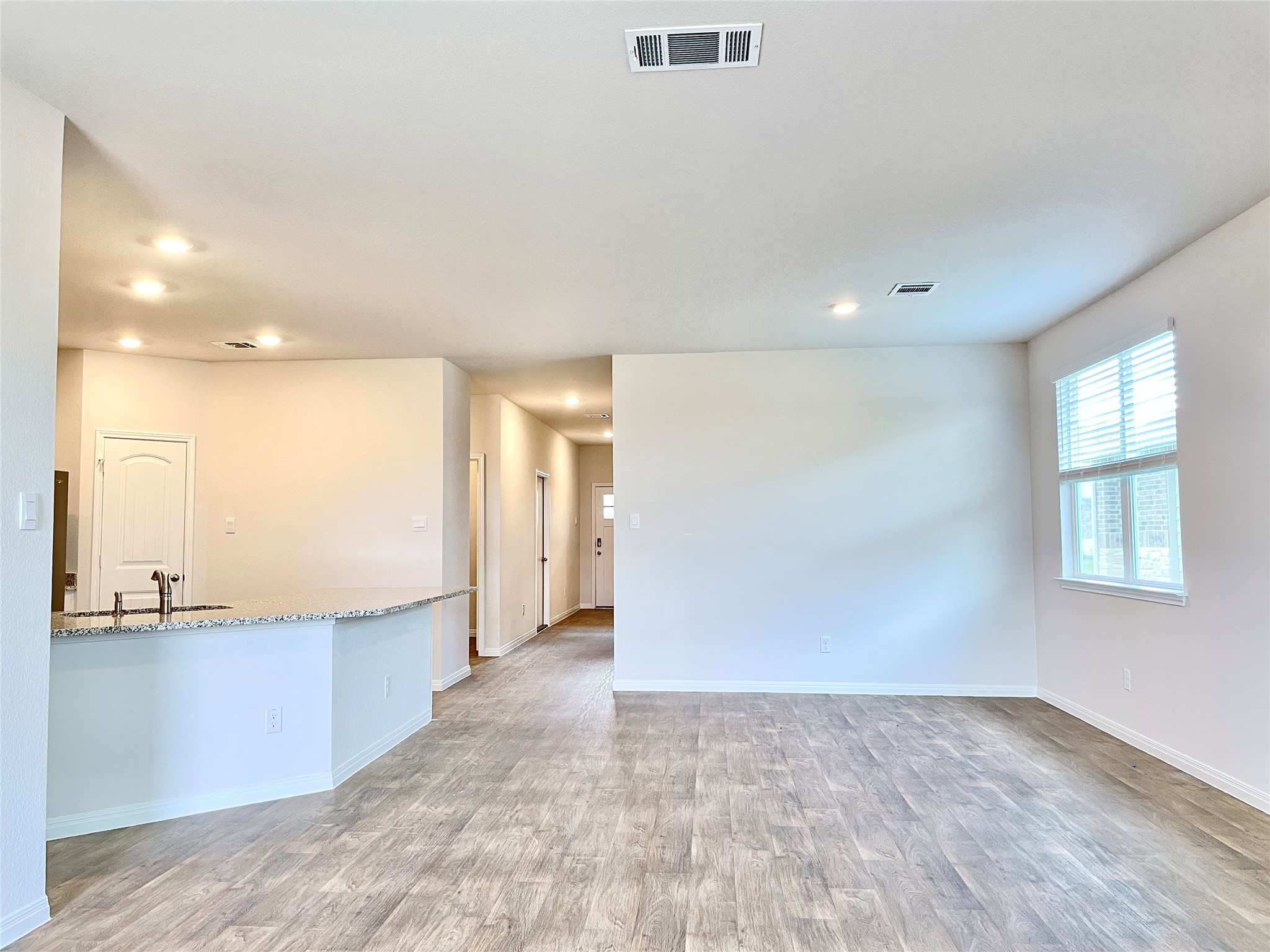 467 Evergreen Sumac Loop Kyle, TX 78640 - Photo 19 of 40 an empty room with a kitchen and windows