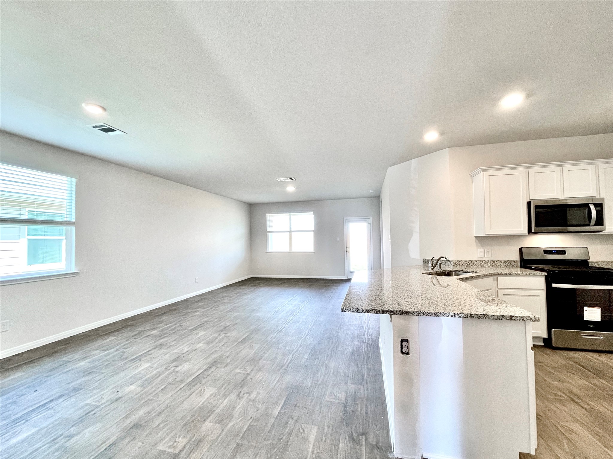 467 Evergreen Sumac Loop Kyle, TX 78640 - Photo 5 of 40 a view of a kitchen with microwave and wooden floor