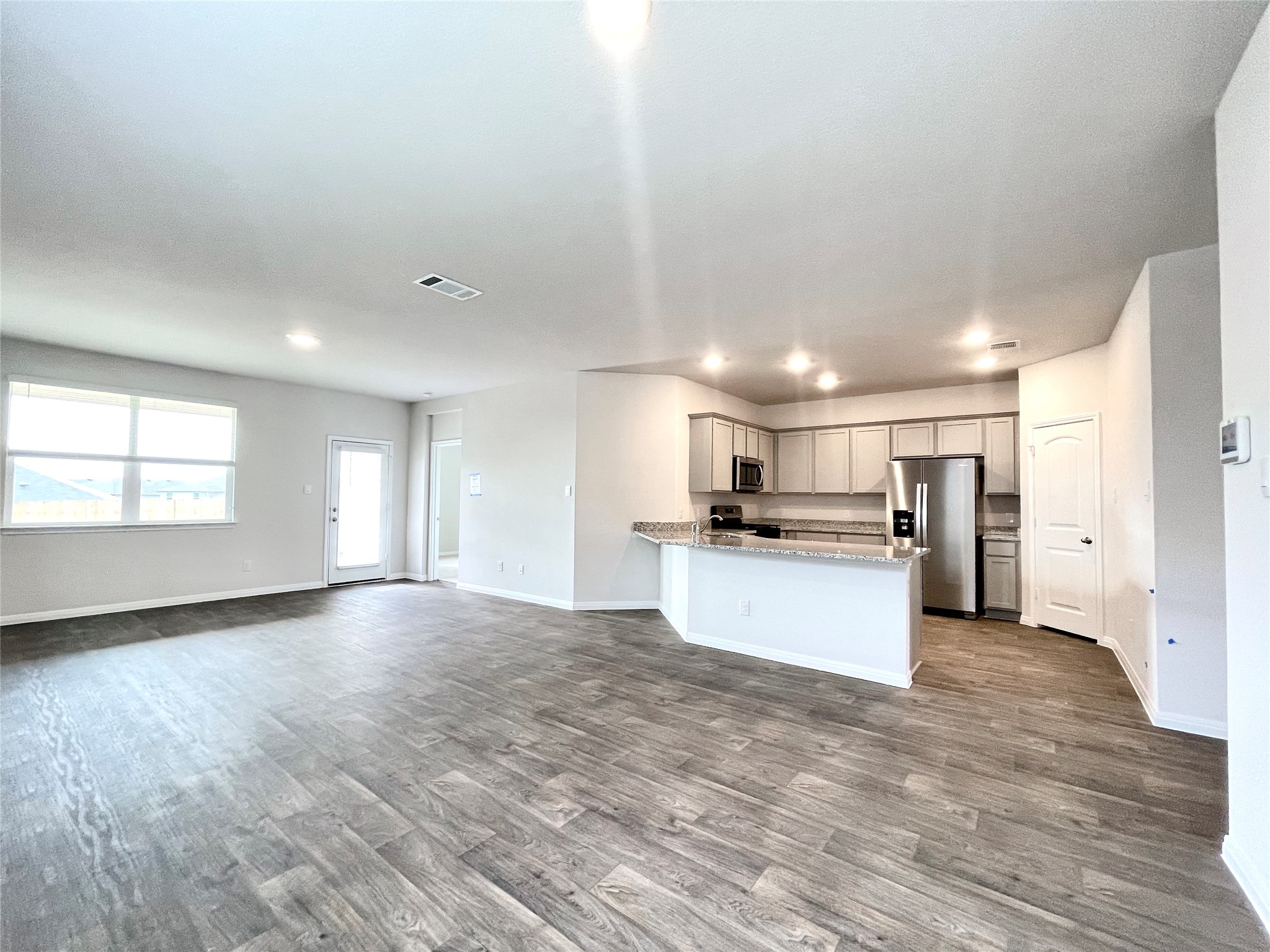 467 Evergreen Sumac Loop Kyle, TX 78640 - Photo 7 of 40 a view of kitchen with kitchen island a sink wooden floor and stainless steel appliances