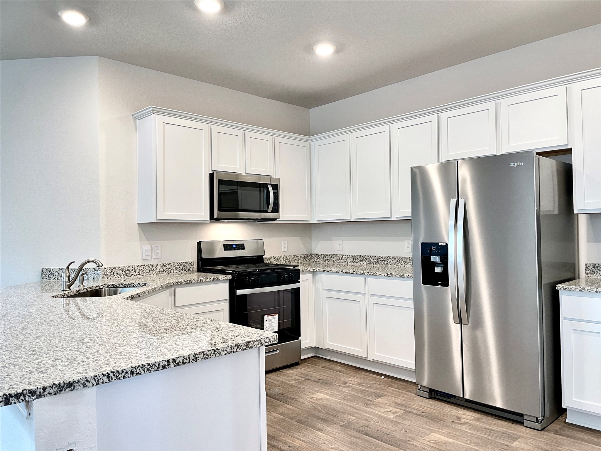 467 Evergreen Sumac Loop Kyle, TX 78640 - Photo 10 of 40 a kitchen with granite countertop a refrigerator sink and microwave