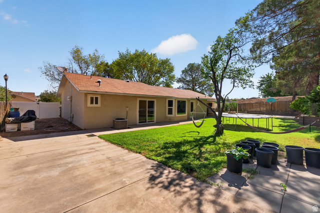 1690 Maplewood Way St. George, UT 84790 - Photo 16 of 17 Expansive backyard featuring a manicured lawn, established trees, and a concrete patio