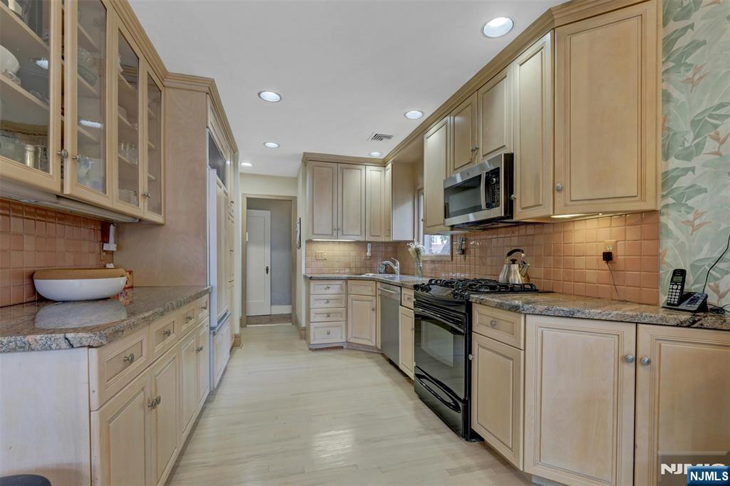 548 Standish Road Teaneck, NJ 07666 - Photo 14 of 28 a kitchen with stainless steel appliances granite countertop a sink and a stove