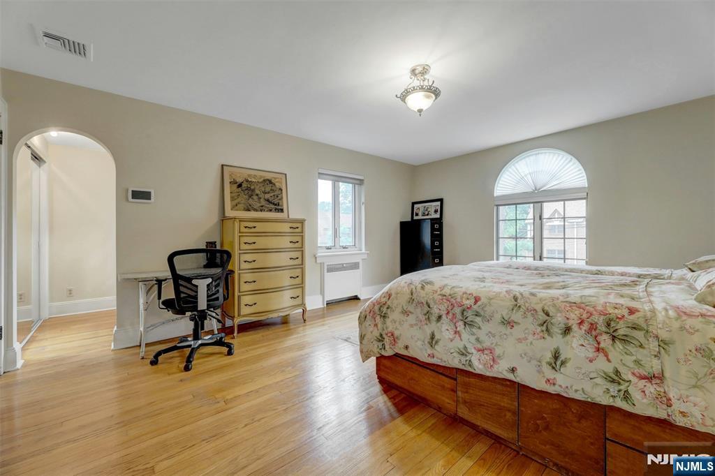 548 Standish Road Teaneck, NJ 07666 - Photo 18 of 28 a bedroom with a bed and a chandelier