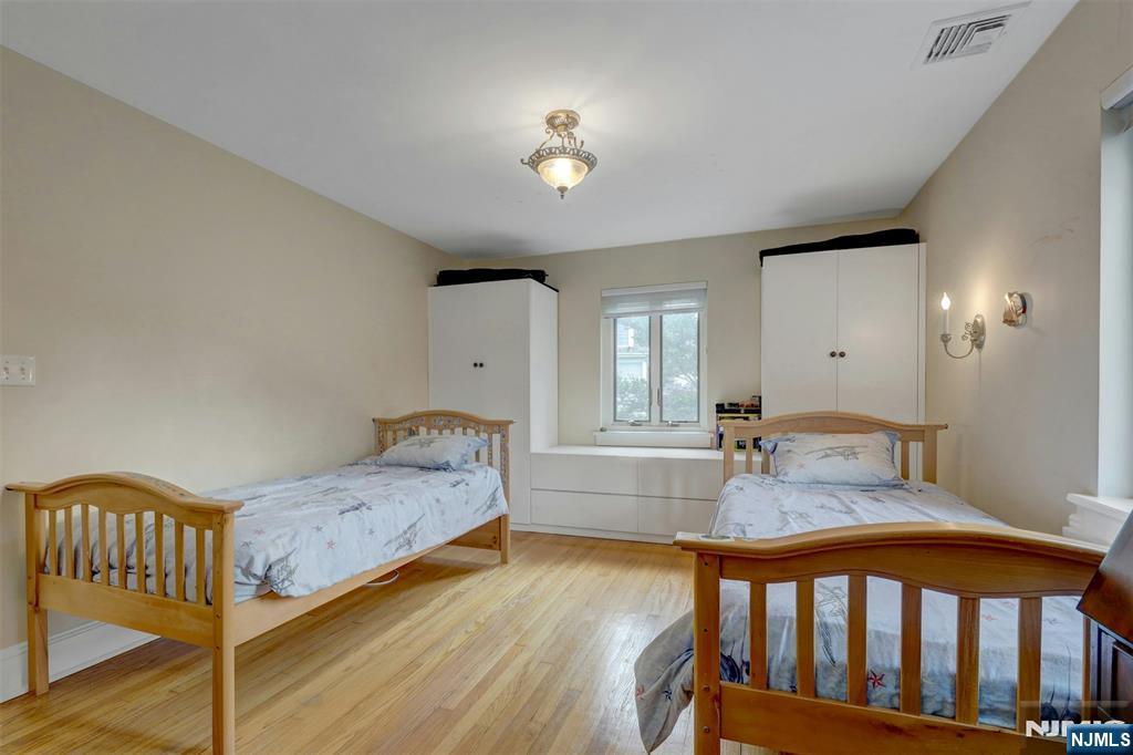 548 Standish Road Teaneck, NJ 07666 - Photo 21 of 28 a bedroom with a bed and wooden floor