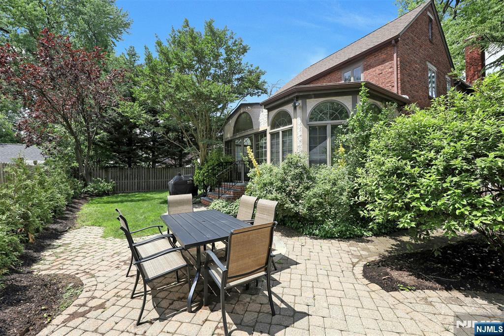 548 Standish Road Teaneck, NJ 07666 - Photo 24 of 28 a view of a patio with table and chairs potted plants and floor to ceiling window