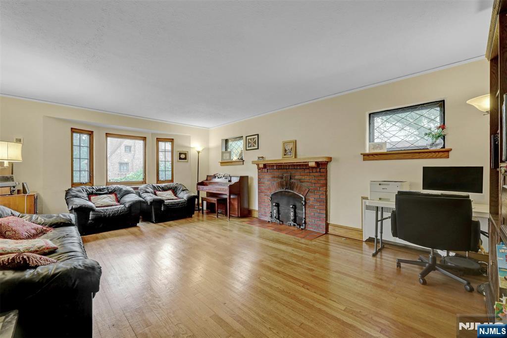 548 Standish Road Teaneck, NJ 07666 - Photo 5 of 28 a living room with furniture a fireplace and a flat screen tv