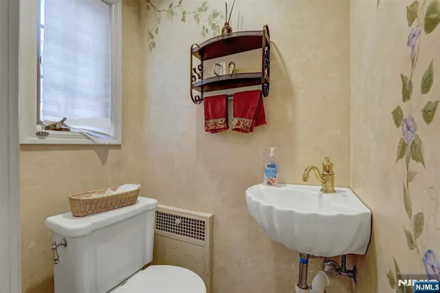 a bathroom with a toilet a sink and a mirror