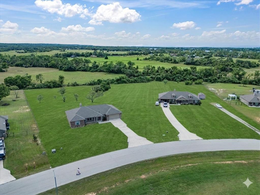 129 Springwood Ranch Loop Springtown, TX 76082 - Photo 5 of 26 Spacious property featuring a large single-story residence with an attached garage and an extensive green lawn