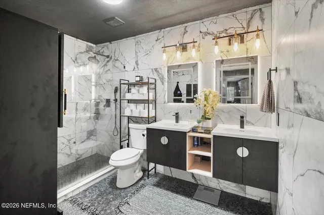 a spacious bathroom with a shower sink mirror and toilet
