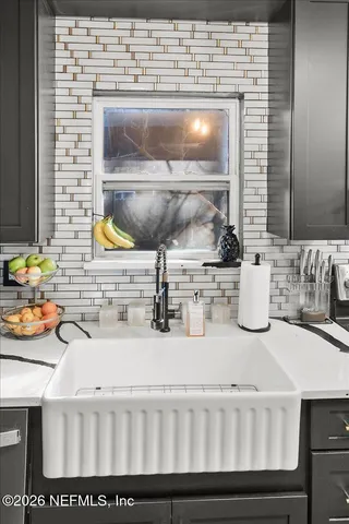 a kitchen with a sink and a stove with wooden floor