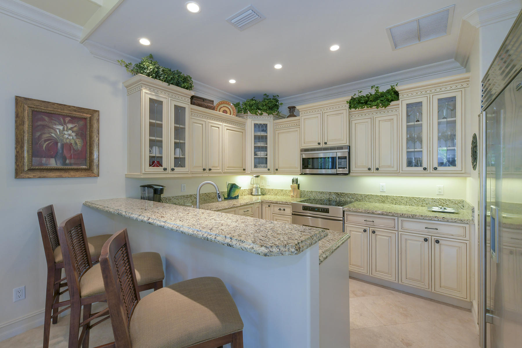 58 Sunset Key Drive Key West, FL 33040 - Photo 13 of 35 a kitchen with stainless steel appliances granite countertop a table chairs sink and cabinets