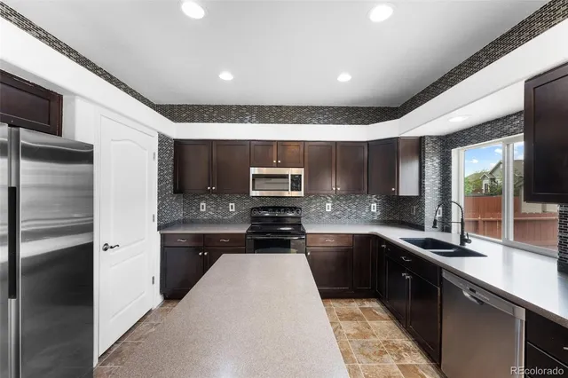a kitchen with stainless steel appliances granite countertop a sink and stove top oven