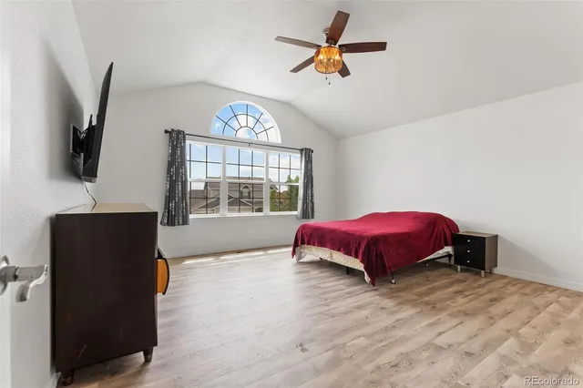 a spacious bedroom with a bed and a flat screen tv