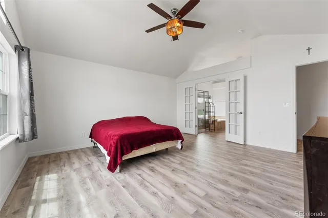 a view of a livingroom with wooden floor and a ceiling fan