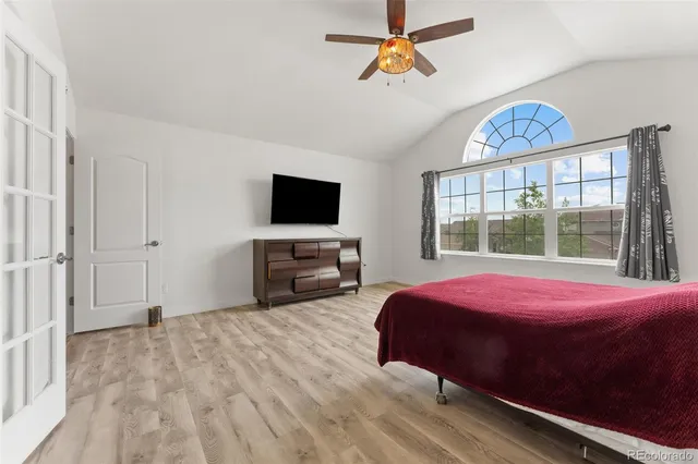 a bedroom with a bed a chandelier and a window