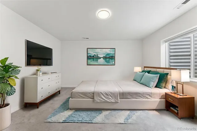 a spacious bedroom with a large bed and a flat screen tv