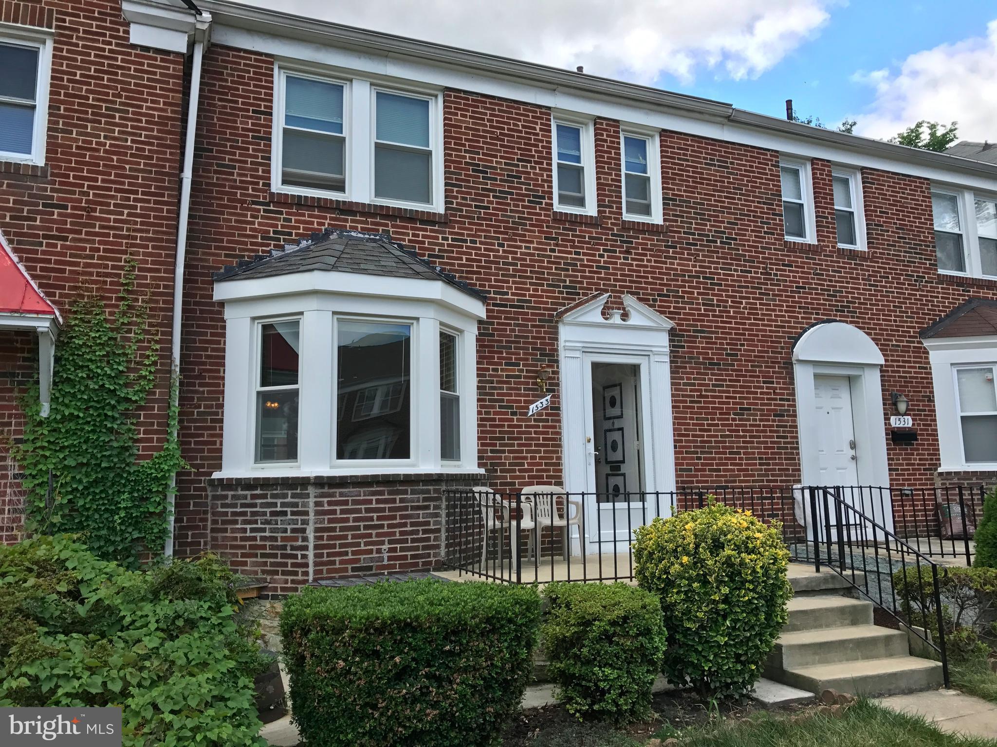 1533 Northgate Road Baltimore, MD 21218 - Photo 2 of 18 a view of a brick house with large windows and a yard