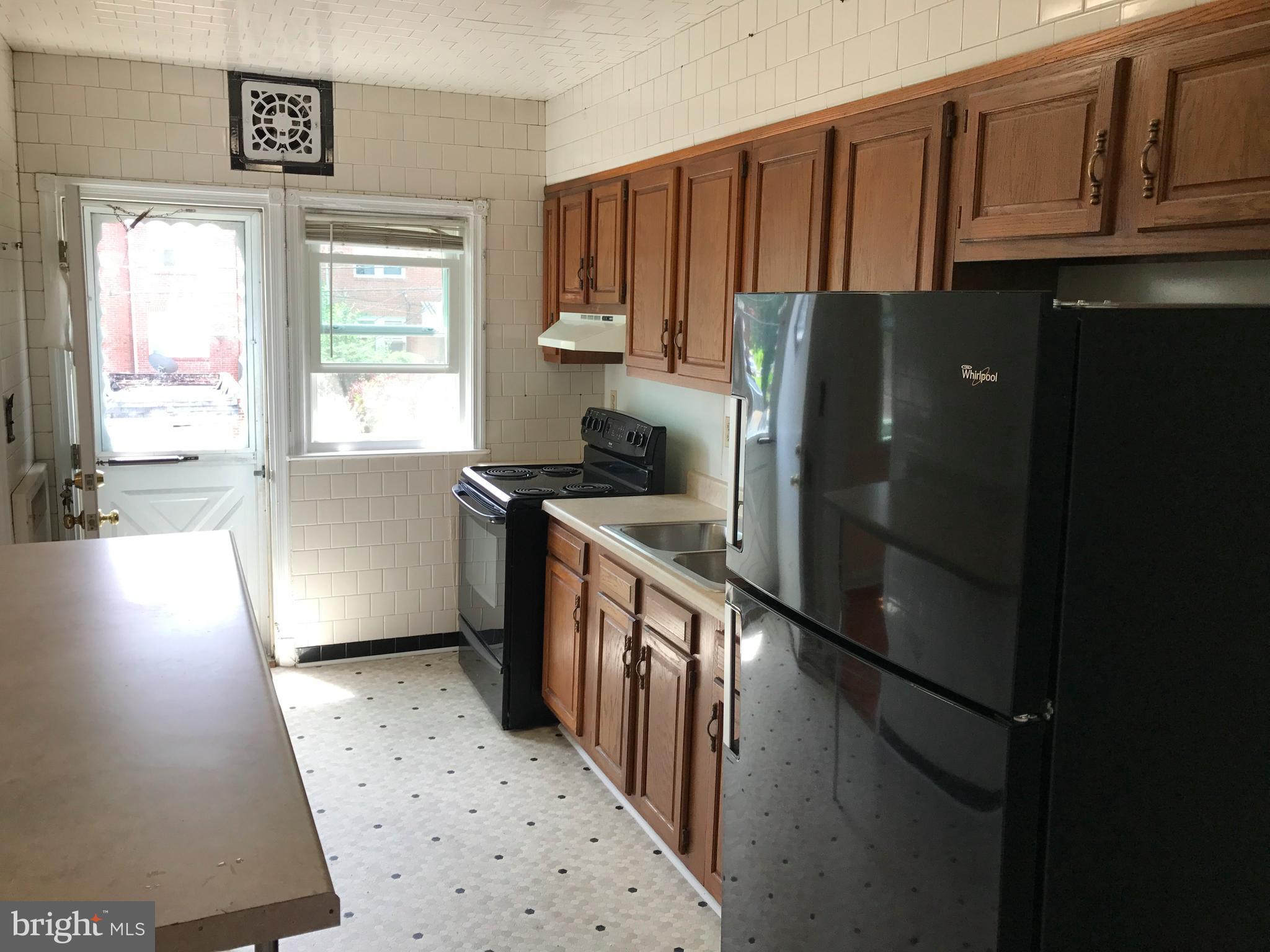1533 Northgate Road Baltimore, MD 21218 - Photo 3 of 18 a kitchen with stainless steel appliances granite countertop a refrigerator a stove a sink and dishwasher with wooden floor