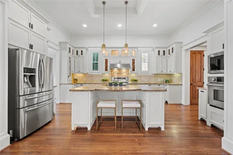 a kitchen with stainless steel appliances granite countertop a sink refrigerator and cabinets