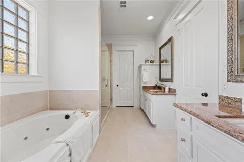 a bathroom with a tub a sink and a large mirror