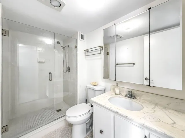 a bathroom with a sink toilet double vanity and shower
