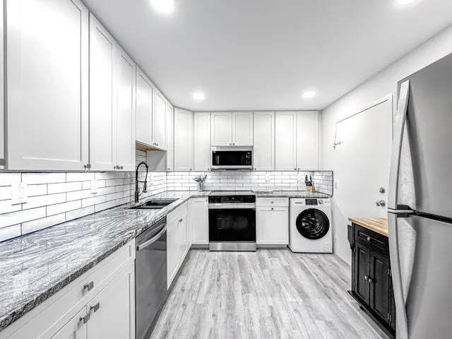 a kitchen with stainless steel appliances granite countertop a sink a stove and cabinets