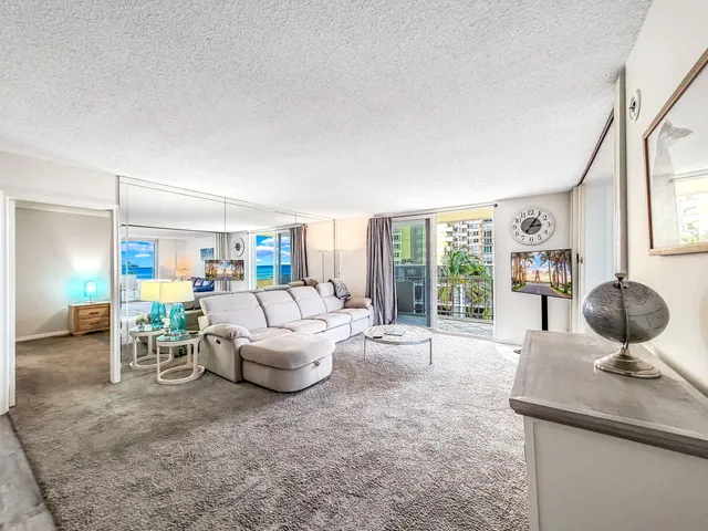 a living room with furniture and a dining table with rug