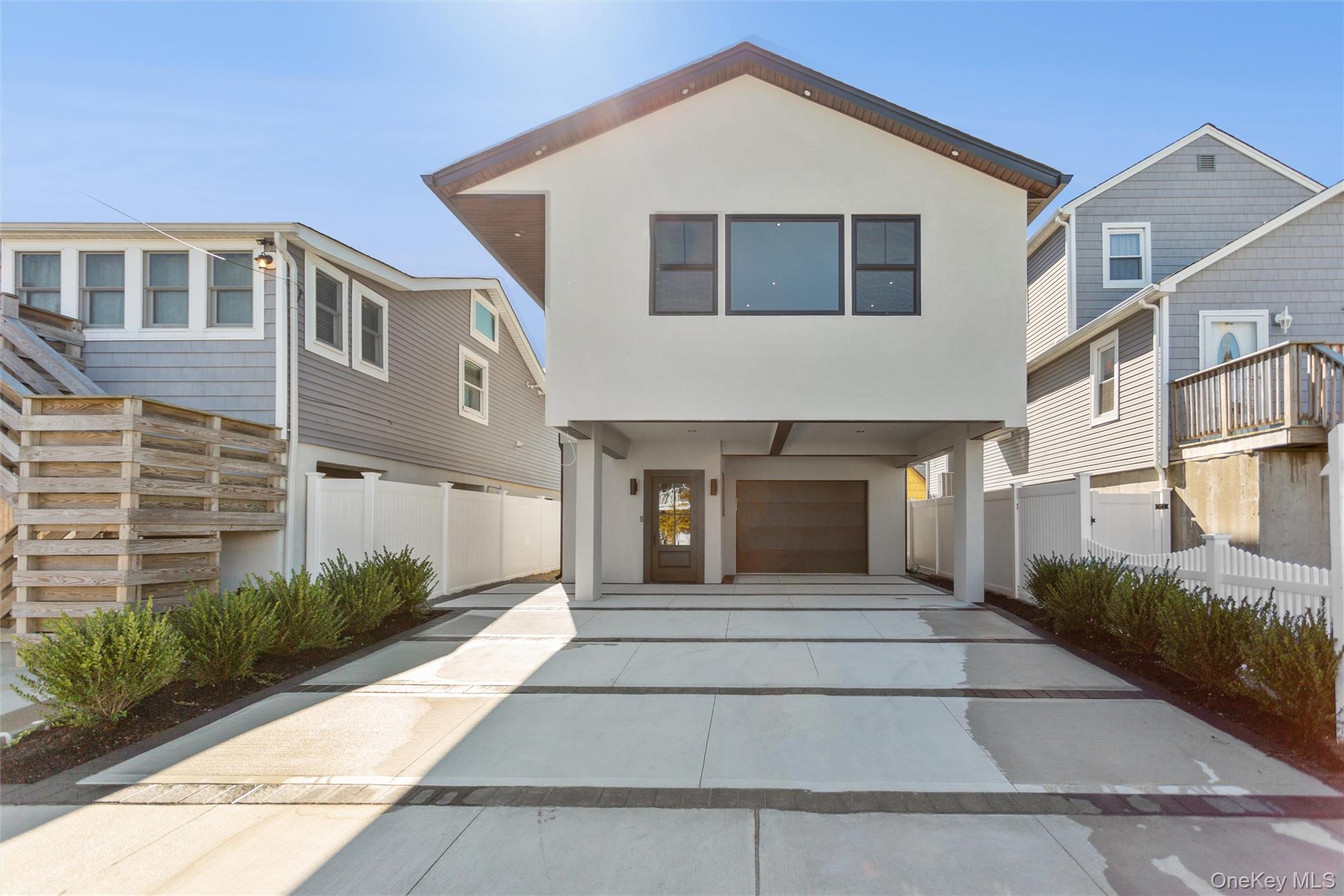 31 Kent Road, Unit NEW CONSTRUCTION Island Park, NY 11558 - Photo 1 of 1 View of front of property featuring stucco siding, concrete driveway, and a residential view