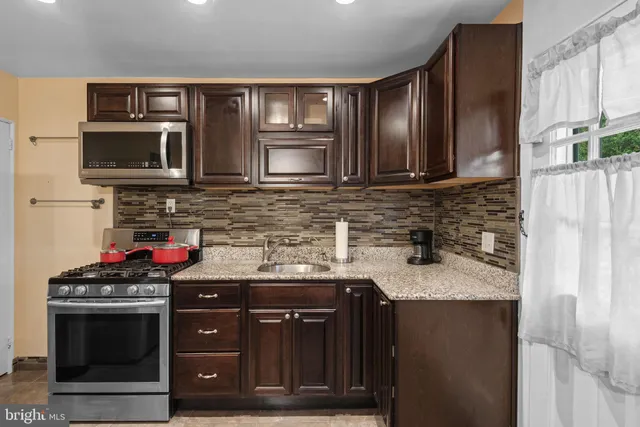 a kitchen with stainless steel appliances granite countertop a stove a microwave and a sink