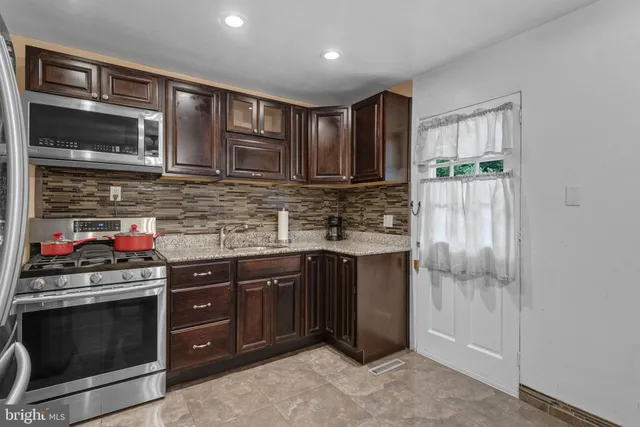 a kitchen with stainless steel appliances granite countertop a stove and cabinets